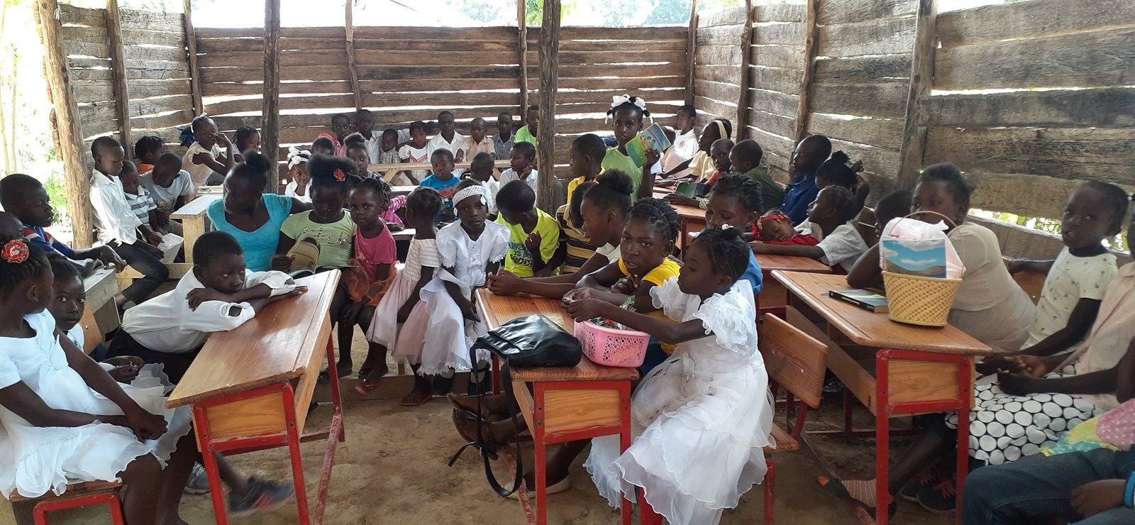 Grand groupe assis dans une salle communautaire pendant une activité collective.