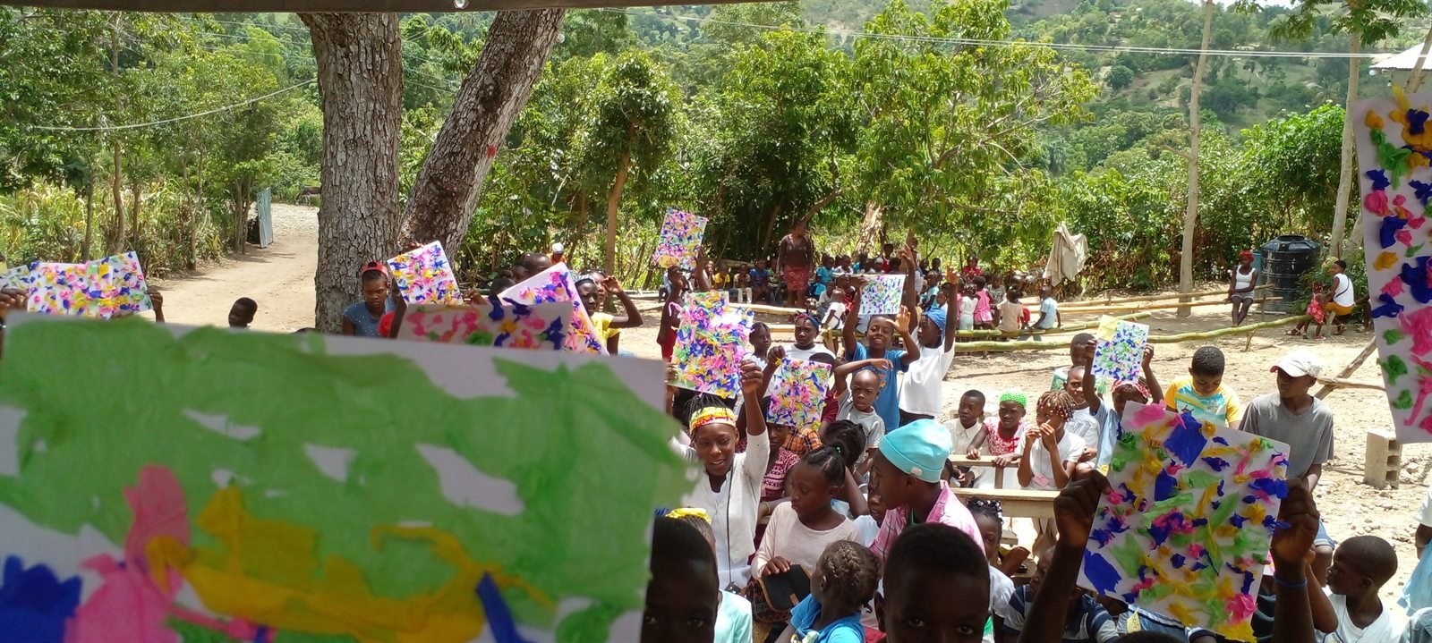 Enfants réunis dehors avec des boîtes de cadeaux colorées pendant une activité sociale.